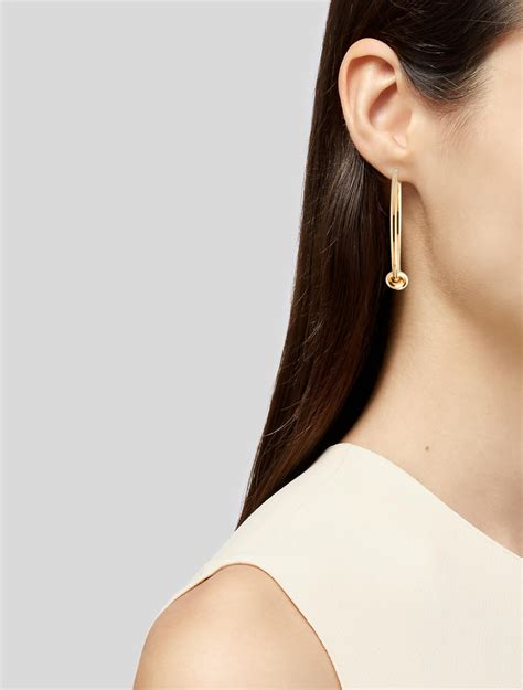 celine knot earring|Celine knot hoop earrings.